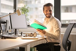 Office worker smiling at PC